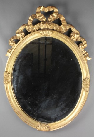 A Victorian style oval plate wall mirror contained in a decorative gilt frame, surmounted by a ribbon and garland 29"h x 21"w