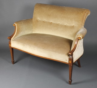 An Edwardian 2 seat settee upholstered in buttoned material, raised on square tapering supports, spade feet 