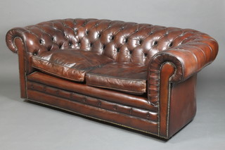 A 2 seat Chesterfield settee upholstered in brown leather 