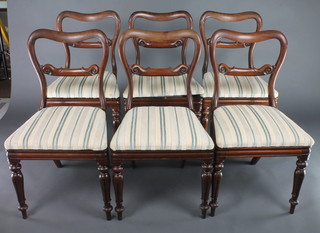 A set of 6 Victorian rosewood buckle back dining chairs with shaped mid rails, raised on turned and fluted supports with upholstered drop in seats 