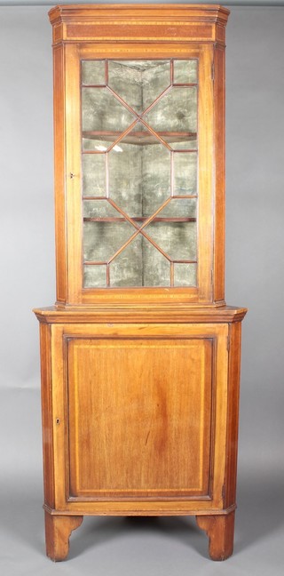 An Edwardian inlaid mahogany corner cabinet with moulded cornice, the upper section fitted shelves enclosed by astragal glazed panelled doors, the base fitted a cupboard enclosed by panelled doors, raised on bracket feet 77"h x 24 1/2"w x 14"d 