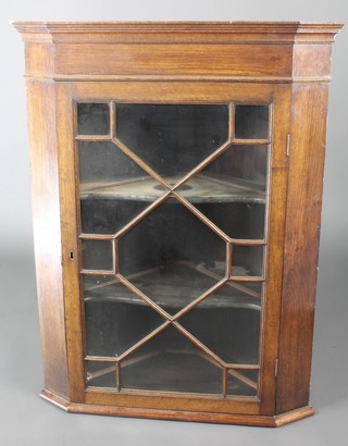 A 19th Century oak hanging corner cabinet with moulded cornice, fitted shelves enclosed by astragal glazed panelled doors 30"h x 18"w x 17"
