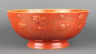 A Ruskin orange glazed bowl with moulded floral decoration, 10" diam. 