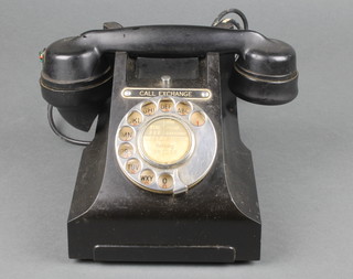 A black Bakelite dial telephone, the base marked 312L 