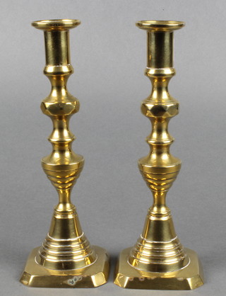 A pair of 19th Century brass candlesticks with knopped stems, raised on square bases complete with ejectors 10" 