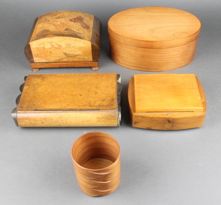 An oval wooden shaker box 4"h x 9 1/2" x 7", ditto cylindrical jar 3"h x 2 1/2" diam., a marquetry musical cigarette box decorated fish and 2 wooden musical jewellery boxes  
