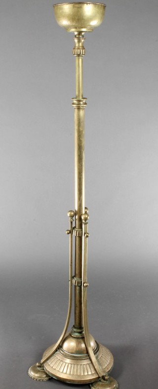 A 19th Century brass adjustable oil lamp stand raised on a circular base with 3 bun feet 