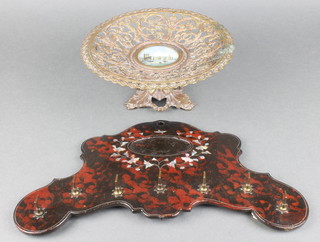 A Victorian pierced gilt metal tazza with panel to the centre decorated The Palace of Westminster 4", a red lacquered and inlaid mother of pearl shaped hanging shoe rack 13" 