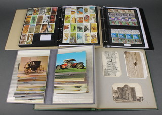A collection of used GB stamps, an album of various modern postcards, a collection of black and white postcards, an album of used GB stamps, an album of tea cards and trade cards 
