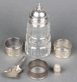 A silver mounted glass sugar shaker Birmingham 1915, 3 silver napkin rings, a caddy spoon and a thimble 