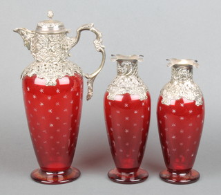 A good Victorian 3 piece ewer decanter set, the lidded ewer with repousse silver decoration of scrolls and flowers having a mask spout and fancy handle, the decanters with repousse silver floral and scroll mounts, all with ruby glass bodies with star cut decoration, the ewer London 1897 12 1/2", the 2 decanters London 1897 and 1898 9", maker William Comyns & Sons Ltd
