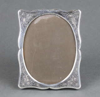 A sterling silver serpentine photograph frame with scroll decoration 5 1/2" x 4 1/2" 