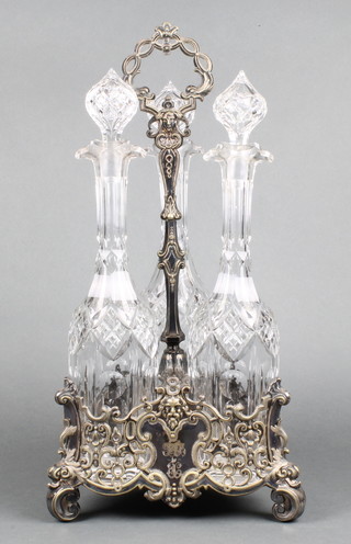 An Edwardian 3 bottle decanter set in a plated trefoil stand with masks, scrolls and shells 18 1/2" 