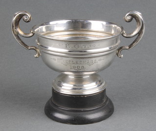 An Edwardian silver 2 handled trophy cup with scroll handles London 1906, 94 grams on a wooden socle 