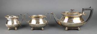 A silver plated 3 piece demi-fluted tea set with ebony mounts on ball feet