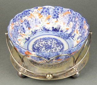 A silver plated bowl stand with swing handle now containing a transfer print Imari bowl 