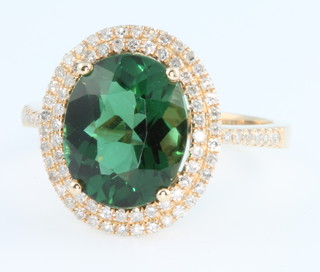 A 14ct yellow gold green tourmaline and diamond cluster ring, the centre stone approx. 3ct surrounded by .7ct of diamond, size N