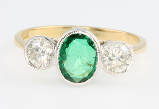 An 18ct yellow gold emerald 1 and diamond 2 stone ring, the centre oval emerald approx. 1ct flanked by brilliant cut diamonds, each approx. 0.4ct, size P 