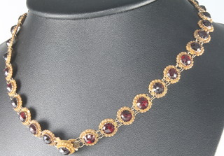 A 19th Century yellow gold garnet set necklace converting to a pair of bracelets 