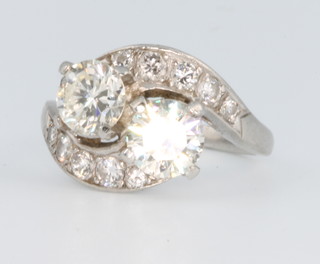 A platinum 2 stone diamond whorl ring, the 2 large stones approx. 1.0ct each with graduated diamond shoulders, size K 
