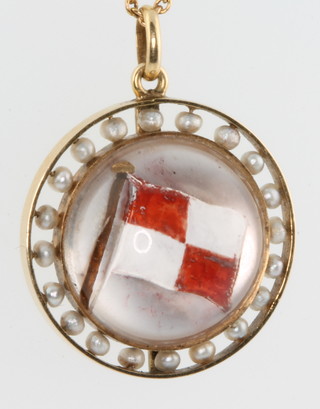 An Edwardian gold and seed pearl mounted reverse intaglio pendant, the reverse in the form of a flag signal (uniform coming into danger) surrounded by 20 seed pearls on a 14ct yellow gold chain 