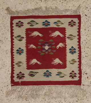 A red ground Tibetan style slip rug decorated birds 17" x 15 1/2" 