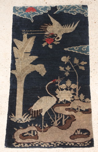 A Chinese blue ground rug decorated storks 50" x 26" 