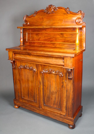 A Victorian mahogany chiffonier with raised shaped back, the base fitted a secret drawer above cupboards enclosed by arched panelled doors, raised on bun feet 64"h x 42"w x 16"d 
 