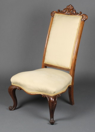 A Victorian carved rosewood show frame nursing chair, the seat and back upholstered in white material, raised on cabriole supports