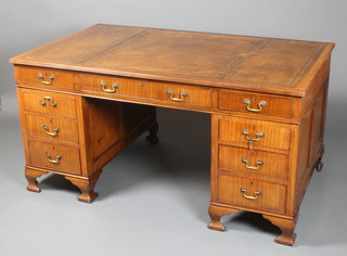 An Edwardian mahogany partners desk with brown leather writing surface above 2 long and 16 short drawers with brass swan neck drop handles and escutcheons, raised on ogee bracket feet 30"h x 69"w x 36"w 

