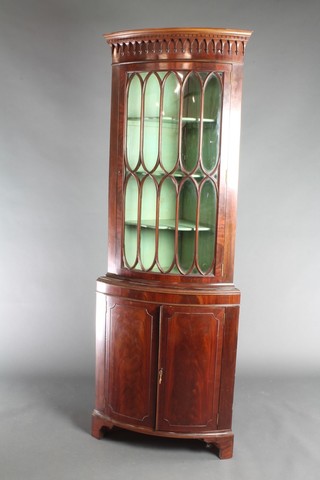 A Georgian style mahogany double corner cabinet, the upper section with moulded and dentil cornice, fitted shelves enclosed by astragal glazed panelled doors, the base fitted a cupboard enclosed by a pair of panelled doors, raised on bracket feet 70"h x 24"w x 15"d 