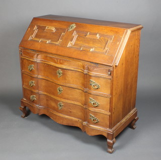 A 17th Century style Continental oak bureau, the fall front revealing a well fitted interior with geometric mouldings, the base with serpentine outline fitted 3 long drawers, raised on cabriole supports 39"h x 40 1/2"w x 18"d  