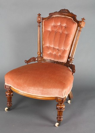 A Victorian carved walnut nursing chair upholstered in mushroom buttoned Dralon, raised on turned supports 