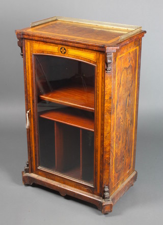 A Victorian figured walnut and crossbanded music cabinet with quarter veneered top and brass three-quarter gallery, fitted shelves enclosed by a glazed panelled door 37"h x 24"w x 16"d 