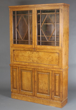 A Victorian Pollard oak secretaire bookcase the upper section fitted adjustable shelves enclosed by astragal glazed panelled doors, the base fitted a fall front with secretaire above a cupboard enclosed by panelled doors, raised on a platform base 78"h x 48"w x 12"d  