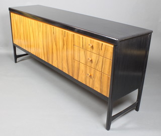 A 1960's rosewood and ebonised sideboard fitted cupboards enclosed by a panelled door flanked by a cocktail unit with fall front and 3 long drawers with tore handles, raised on square supports 31"h x 72"w x 16 1/2"d  