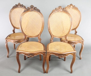 A set of 4 French "rosewood" balloon back dining chairs with carved cresting rails to the top, having woven cane seats and backs, raised on cabriole supports, frames loose and there is damage to the caning 
