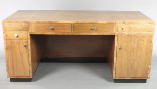 An Art Deco walnut pedestal desk fitted 3 short drawers with an inkwell drawer, the pedestals fitted 2 cupboards with chrome handles and mounts 31"h x 69"w x 29 1/2"d 