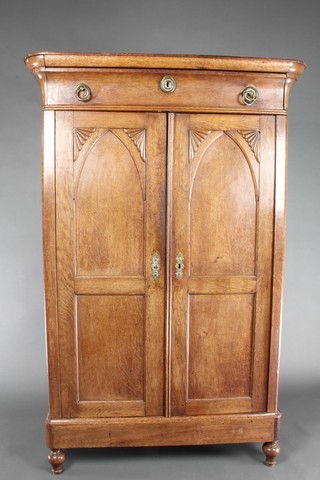 A 19th Century Dutch oak cabinet with moulded cornice fitted 1 long drawer, fitted shelves enclosed by arched panelled doors, raised on bun feet 64"h x 42"w x 19"d 
