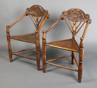 A pair of carved oak Turners chairs with bobbin turned decoration, the front and back carved shields with galleon 