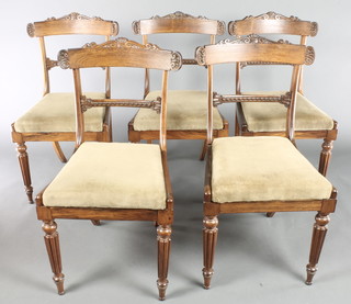 A set of 5 Regency rosewood bar back dining chairs with carved mid rails and drop in seats, raised on turned and reeded supports 