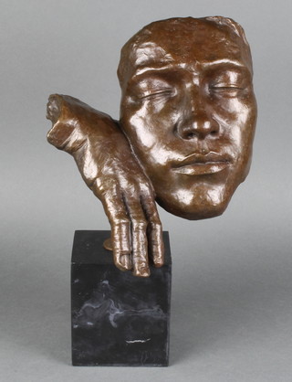 A bronze sculpture in the form of a mask with hand, raised on rectangular black marble base 11" 
