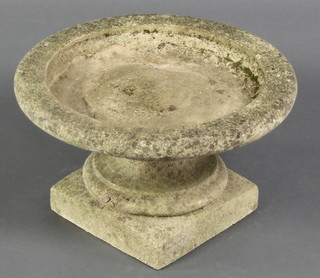 A well weathered circular concrete bird bath/urn, in 2 sections,  raised on turned and square base 9"h x 15" diam.