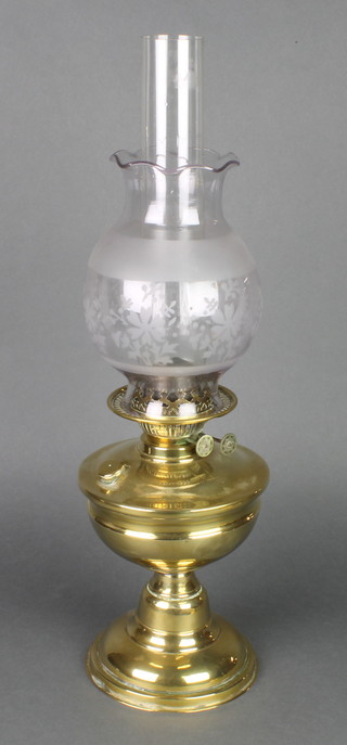 A brass oil lamp with etched glass shade and clear glass chimney, there is 1 small chip to the top and to the bottom of the shade 20"