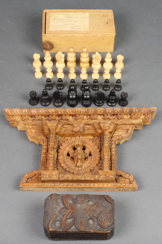 A Maori style carved wooden lozenge shaped box 2" x 4 1/2" x 2 1/2", a carved Indian hardwood plaque together with a carved and pierced Indian hardwood plaque 6" x 11 1/2" and a chess set (1 black pawn is missing and there is damage to the collar of 1 black pawn) 
