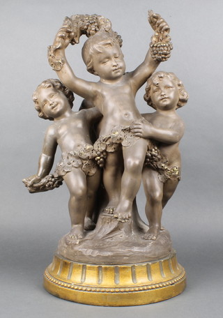 A Continental ceramic group of 3 cavorting cherubs on a raised gilt base 20" 