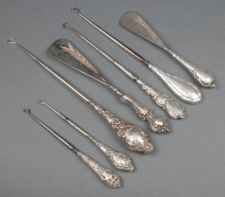 An Edwardian repousse silver button hook, 4 others and 2 shoe horns 