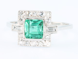 An 18ct white gold Art Deco style emerald and diamond cluster ring, the centre square stone 0.5ct surrounded by 14 brilliant cut diamonds and 2 baguettes, size O 