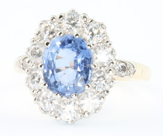 An 18ct yellow gold sapphire and diamond cluster ring, the oval centre stone approx. 1.2ct surrounded by 10 brilliant cut diamonds 2.35ct size P 