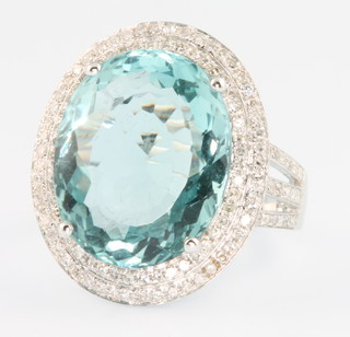 A 14ct white gold aquamarine and diamond oval cluster ring, the centre stone approx. 8.5ct surrounded by 2 tiers of brilliant cut diamonds 1.1ct, size M